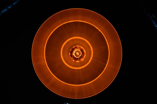 Abstract image of orange light spirals against a dark background